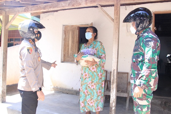 Kapolres Madiun, AKBP Jury Leonard Siahaan, memberikan daging kurban dan beras kepada seorang warga di Kabupaten Madiun, Selasa (20/7/2021). (Istimewa/Polres Madiun)